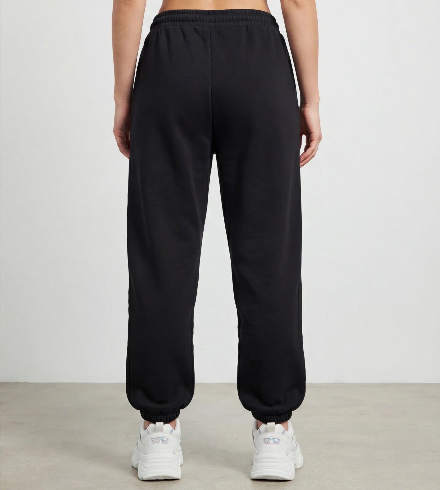 Model wears black fleece joggers. 