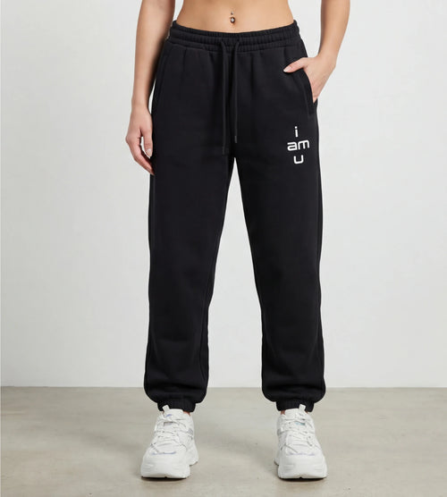 Model wears black fleece joggers featuring an "i am u" graphic. 