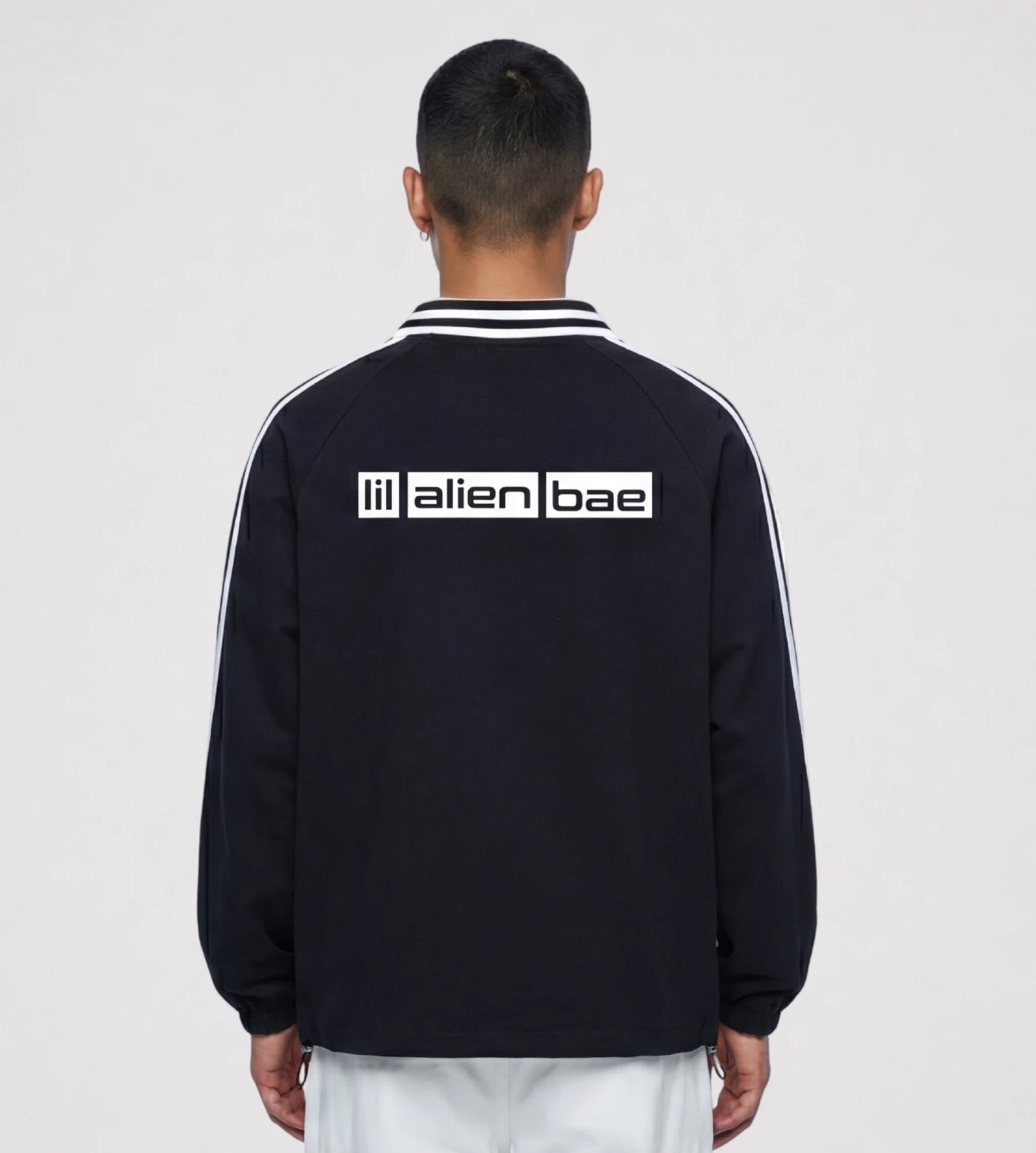 Model wears a Black lapel collar pullover featuring a Lil Alien Bae back graphic. 