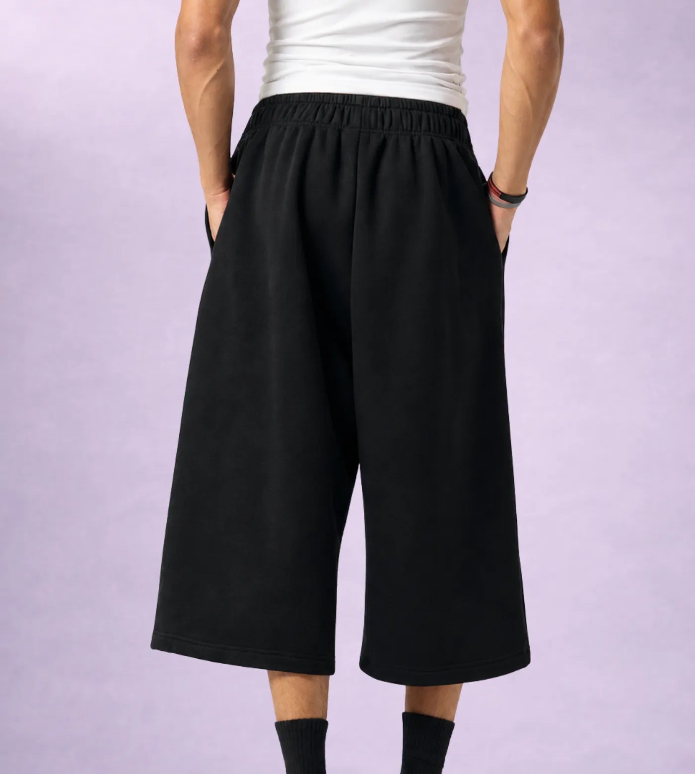 Model wears black fleece mid-length sweat shorts.