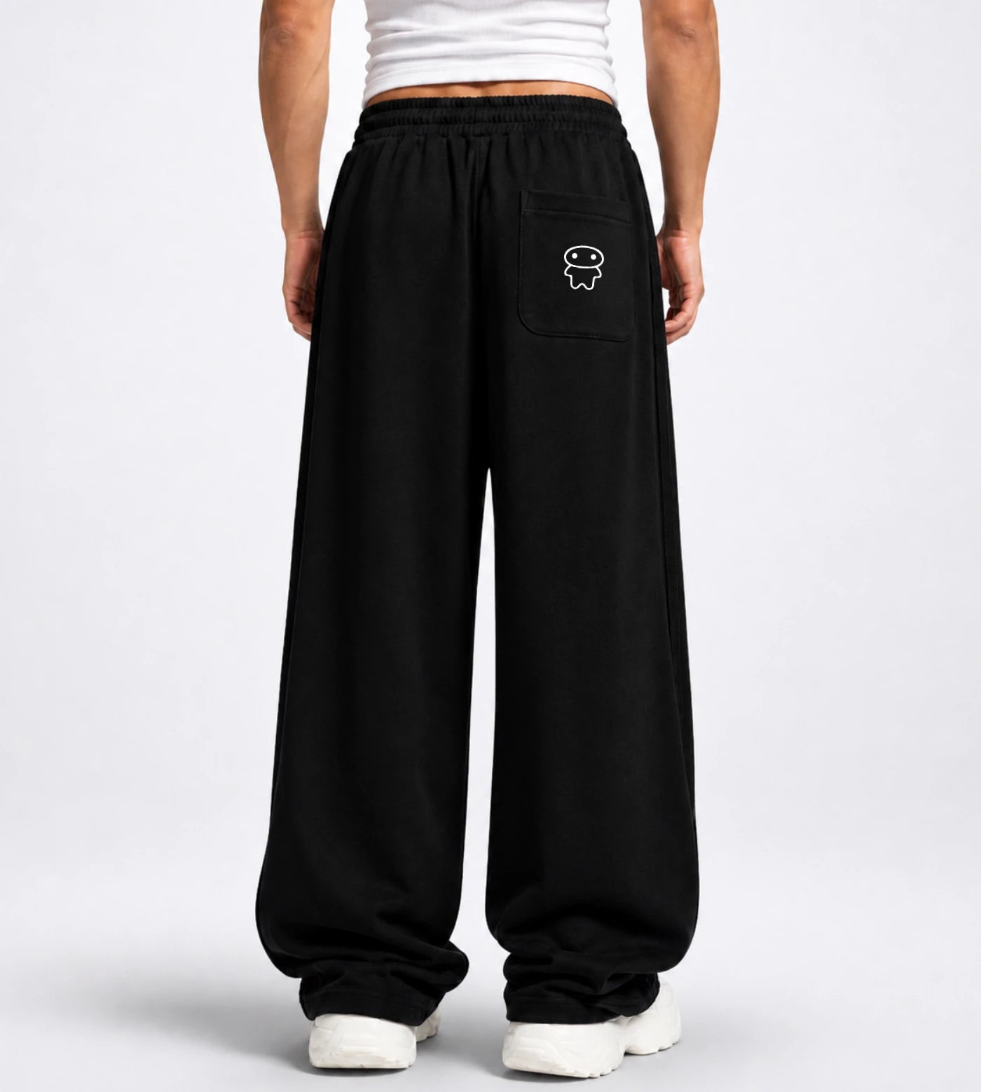 Model wears black straight-leg sweatpants featuring a Lil Alien Bae back pocket.  