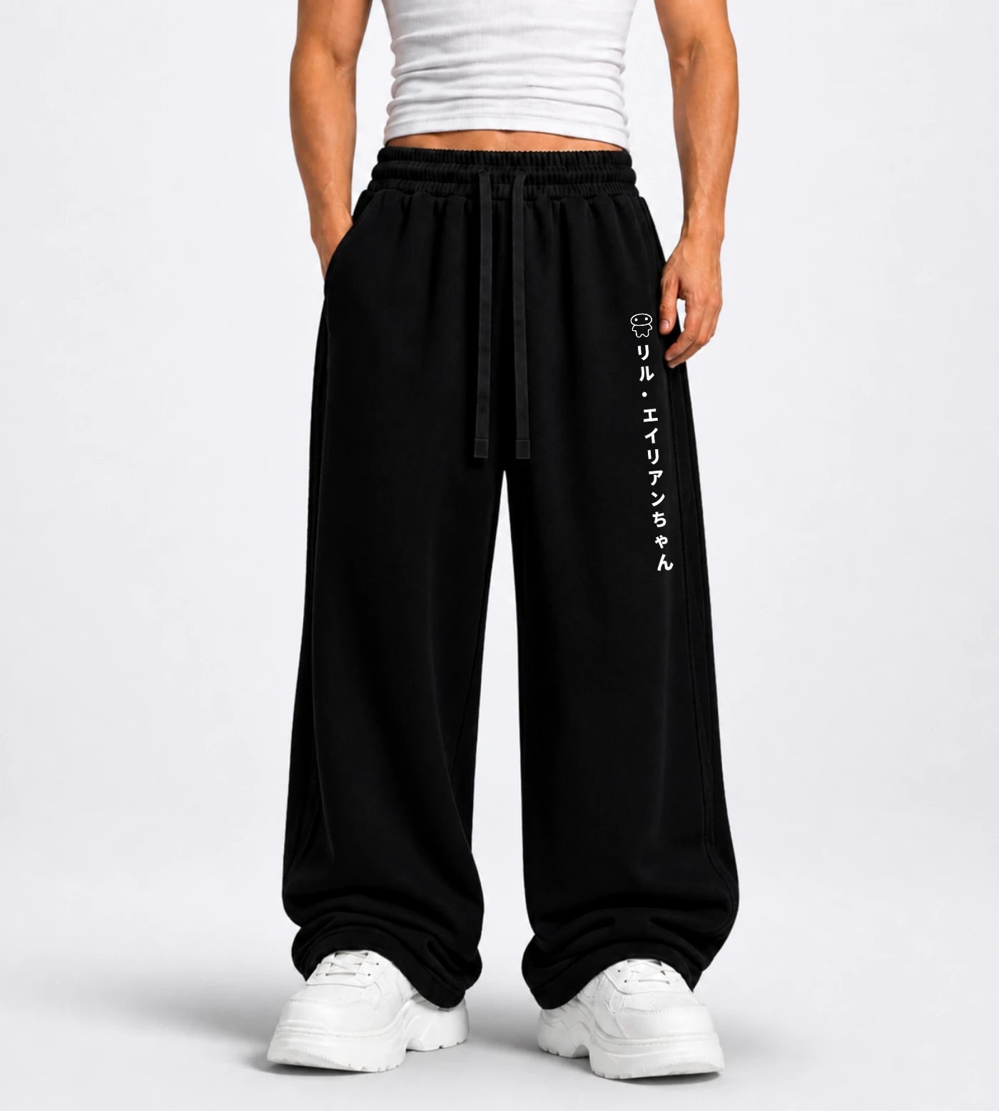 Model wears black straight-leg sweatpants featuring Lil Alien Bae in Japanese.  