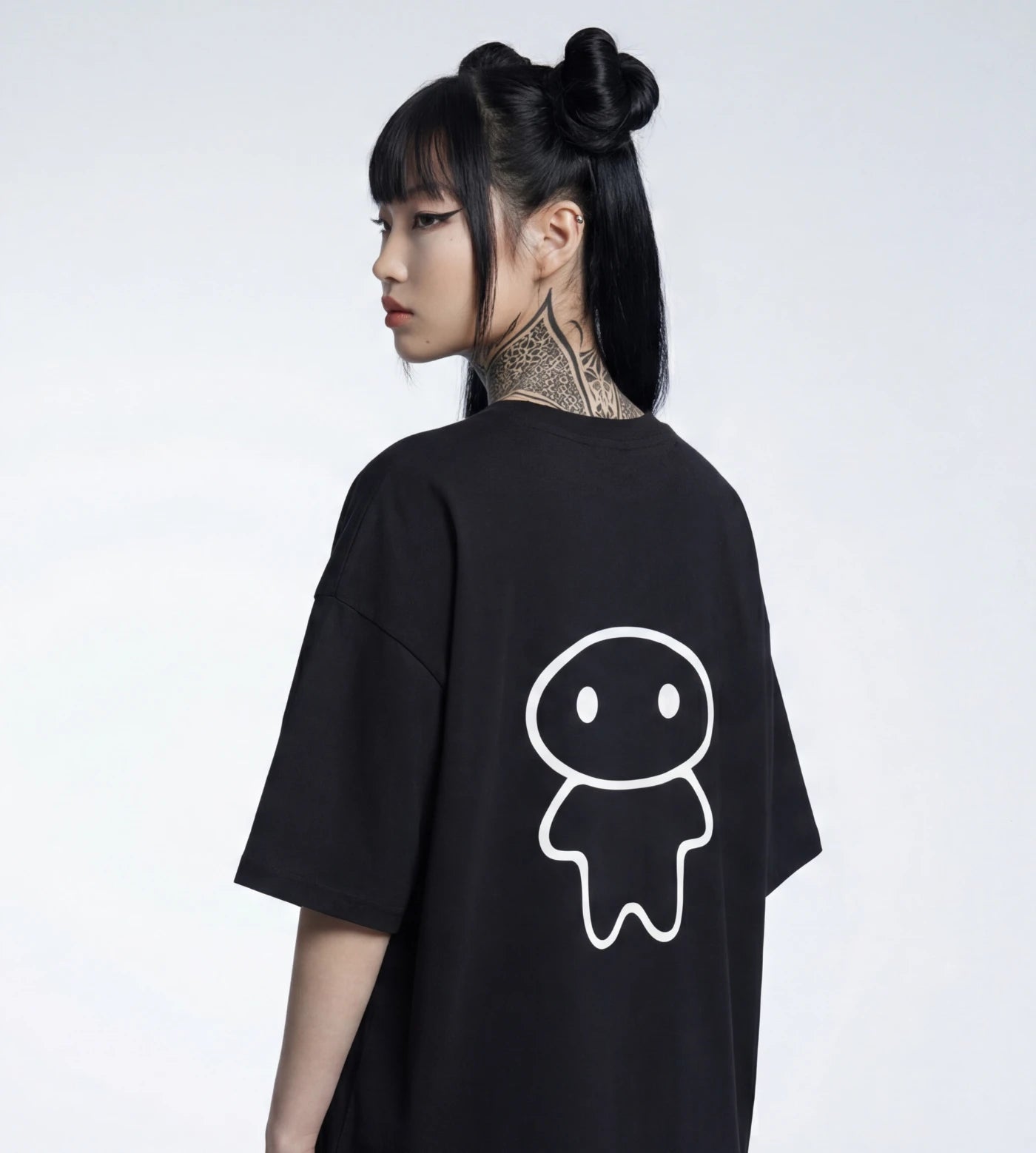 Model's profile view of a black wide fit cotton T-shirt featuring a Lil Alien Bae back graphic. 