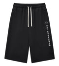 Black athletic shorts with a white drawstring and white vertical Japanese text printed on the left leg, shown against a plain white background.