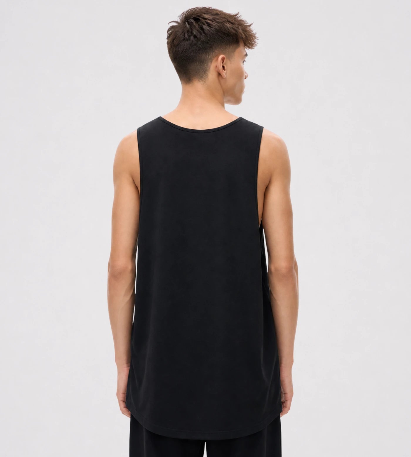 Model wears a black loose fit wide arm cotton tank top.