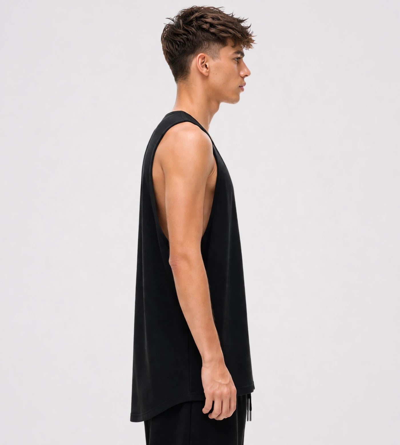 Model wears a black loose fit wide arm cotton tank top.