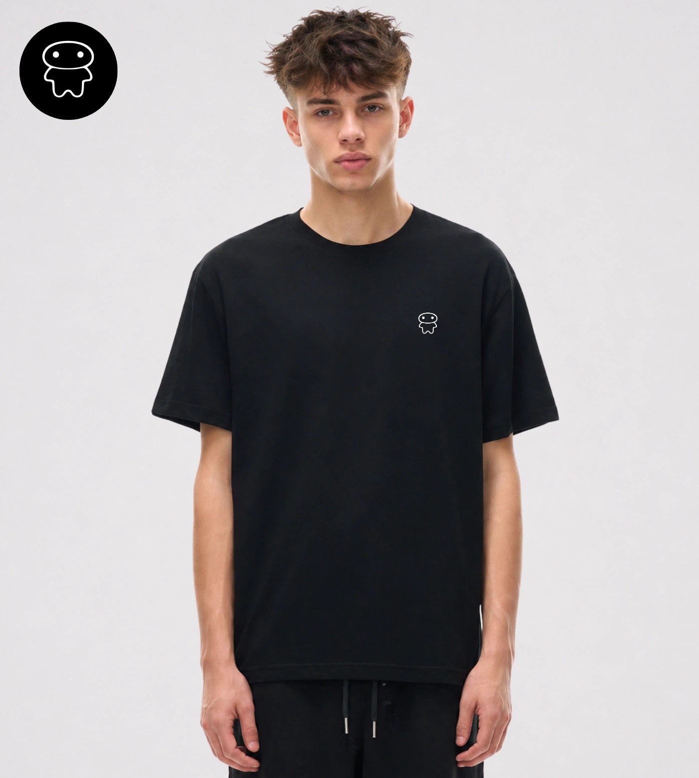 Model wears a relaxed fit black cotton T-shirt featuring a small Lil Alien Bae chest graphic. 