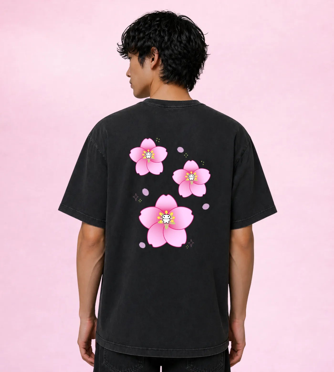 Model wears a vintage washed black oversized T-shirt featuring a Lil Alien Bae sakura back graphic. 