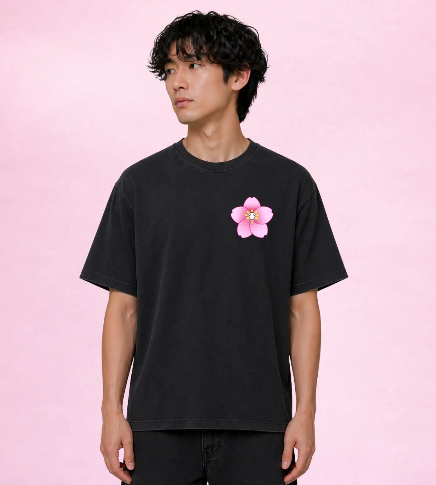 Model wears a vintage washed black oversized T-shirt featuring a Lil Alien Bae sakura chest graphic. 