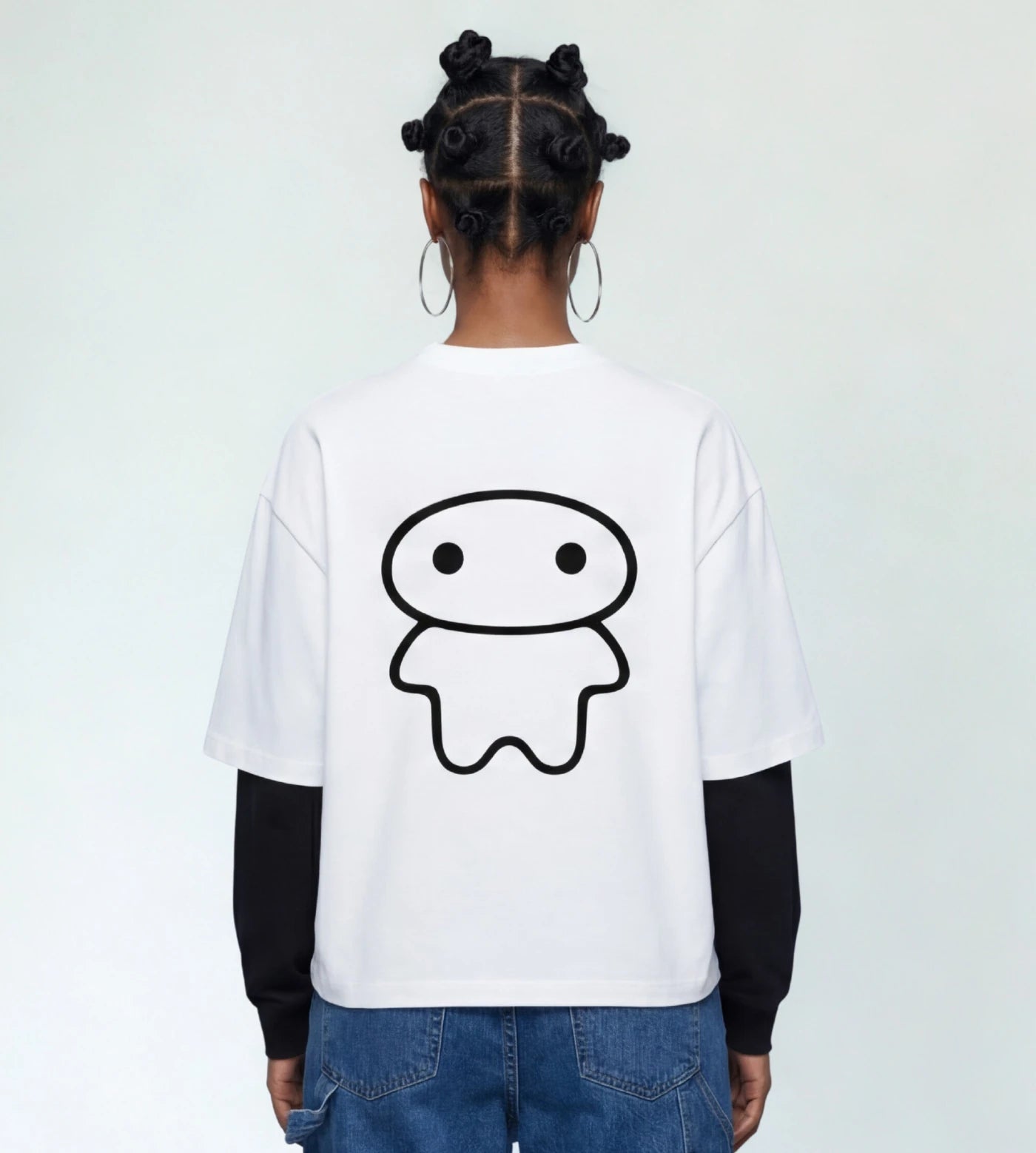 Model wears a white layered long sleeve T-shirt featuring a Lil Alien Bae back graphic. 