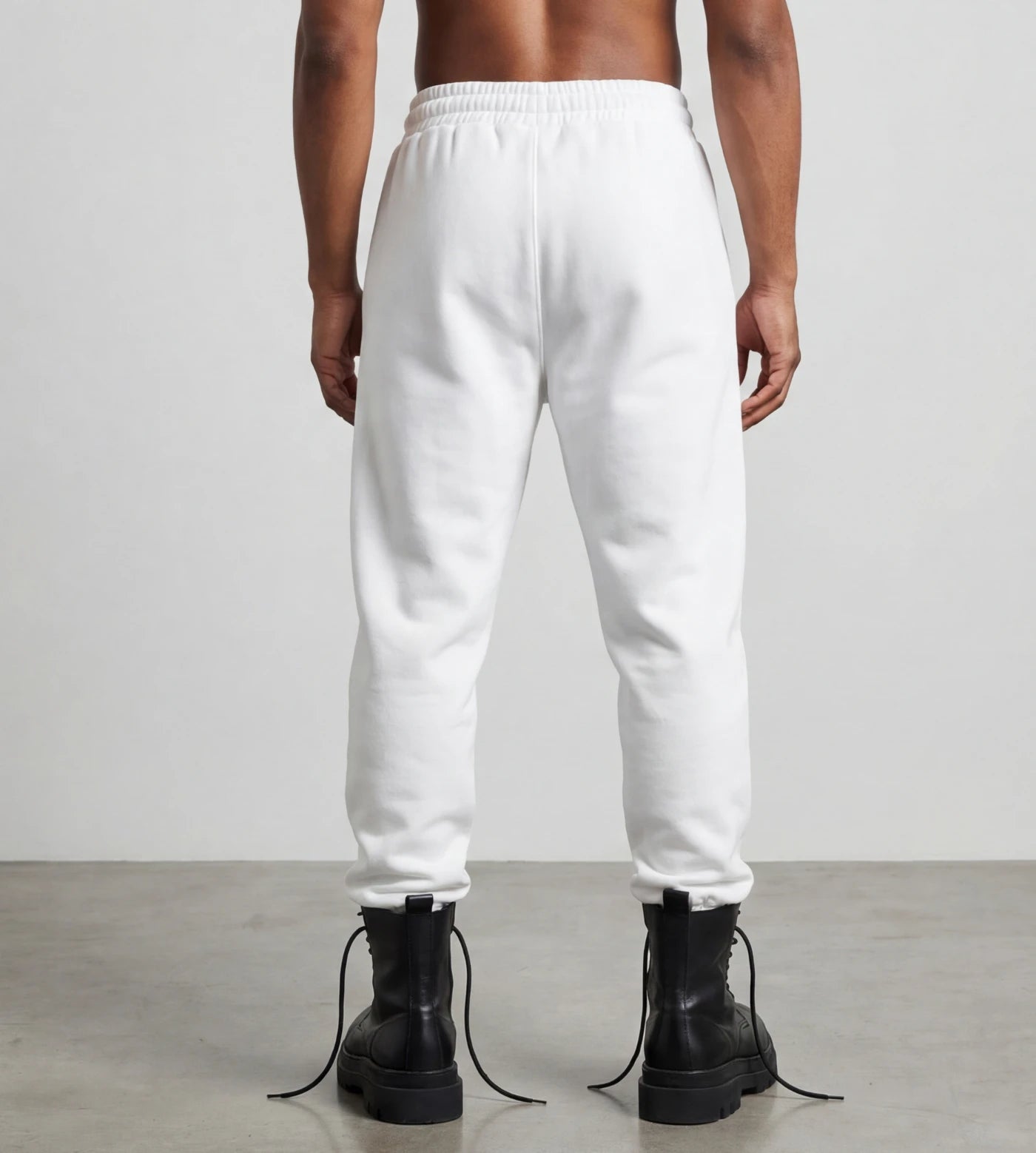 Male model wears white fleece joggers. 
