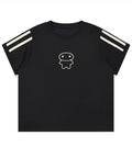 A black short-sleeve t-shirt with two cream-colored stripes on each sleeve and a small cream line-art cartoon face on the center chest, displayed against a solid white background.